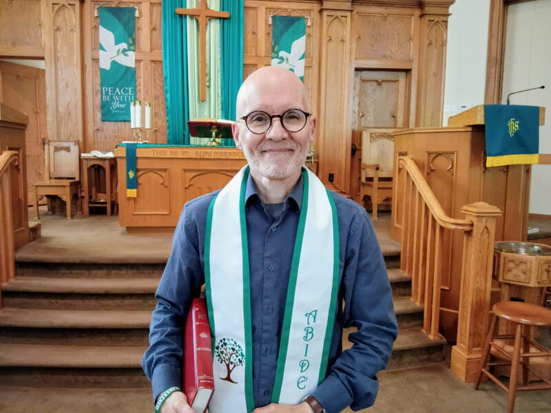 Pastor Michael poses in front of church altar